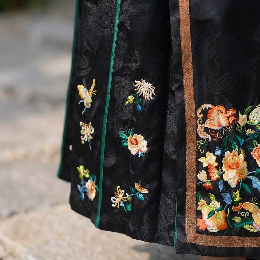 Black embroidered fabric with colorful floral and butterfly designs 