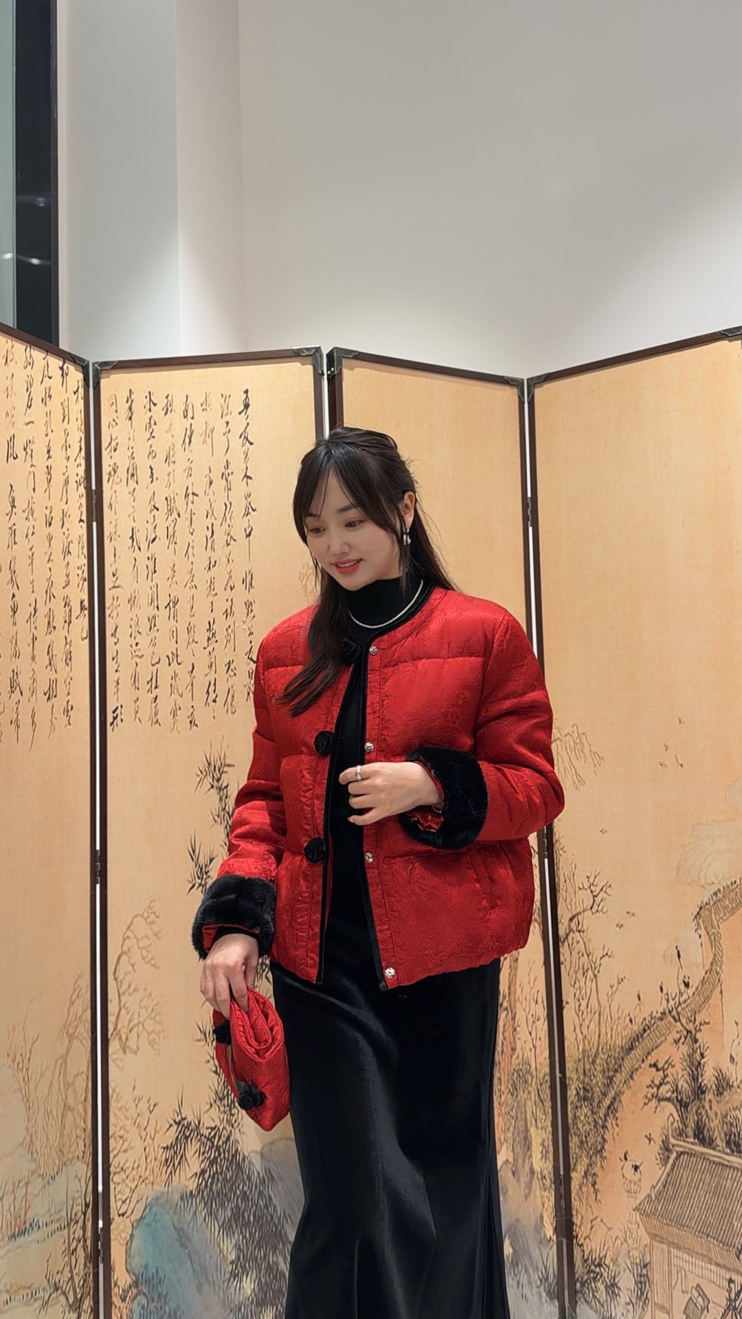 Woman in a red jacket standing in front of an artistic screen
