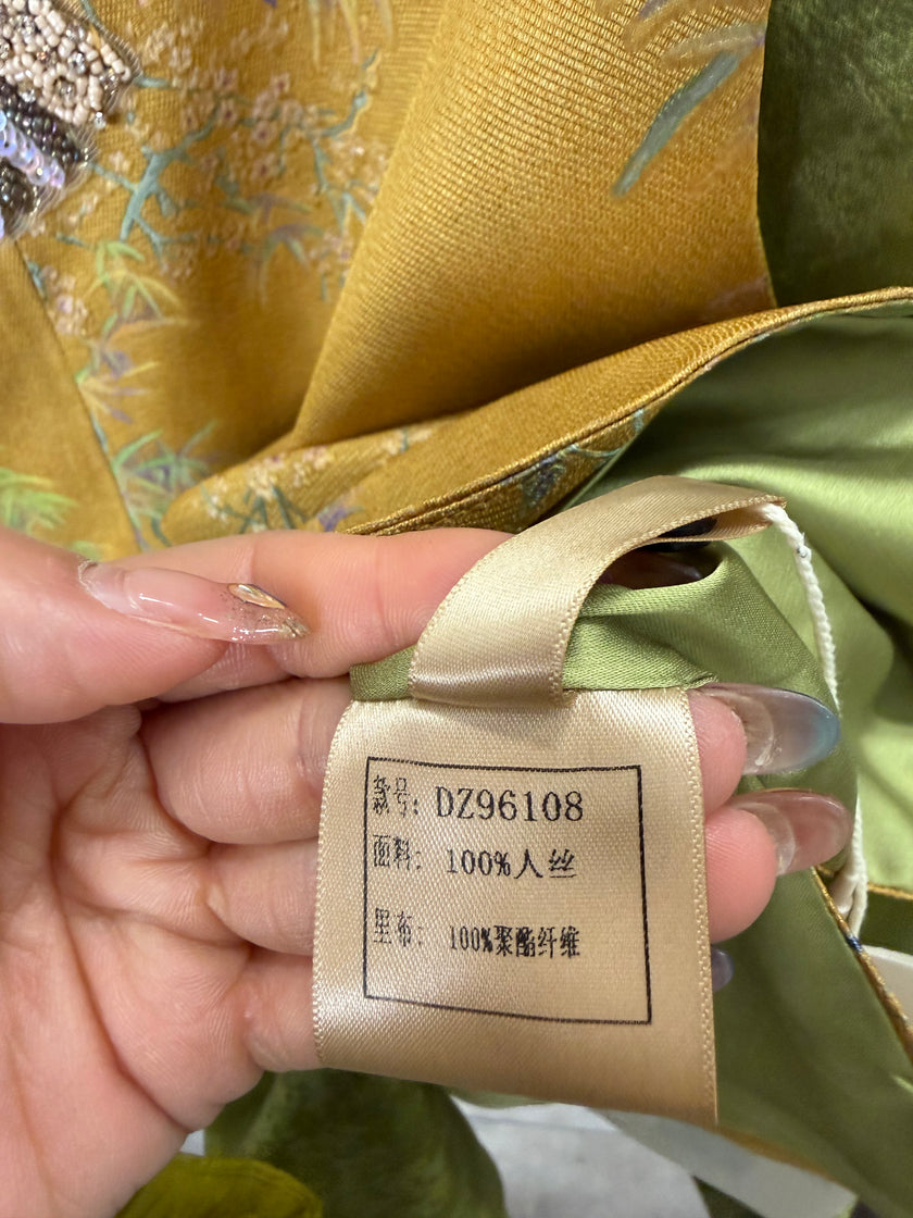 Hand holding a fabric tag with text on a piece of green fabric.