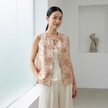 Woman wearing a floral  jacquard vest in a minimalistic room.