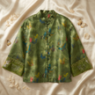 Green embroidered jacket with butterfly patterns on a beige fabric background