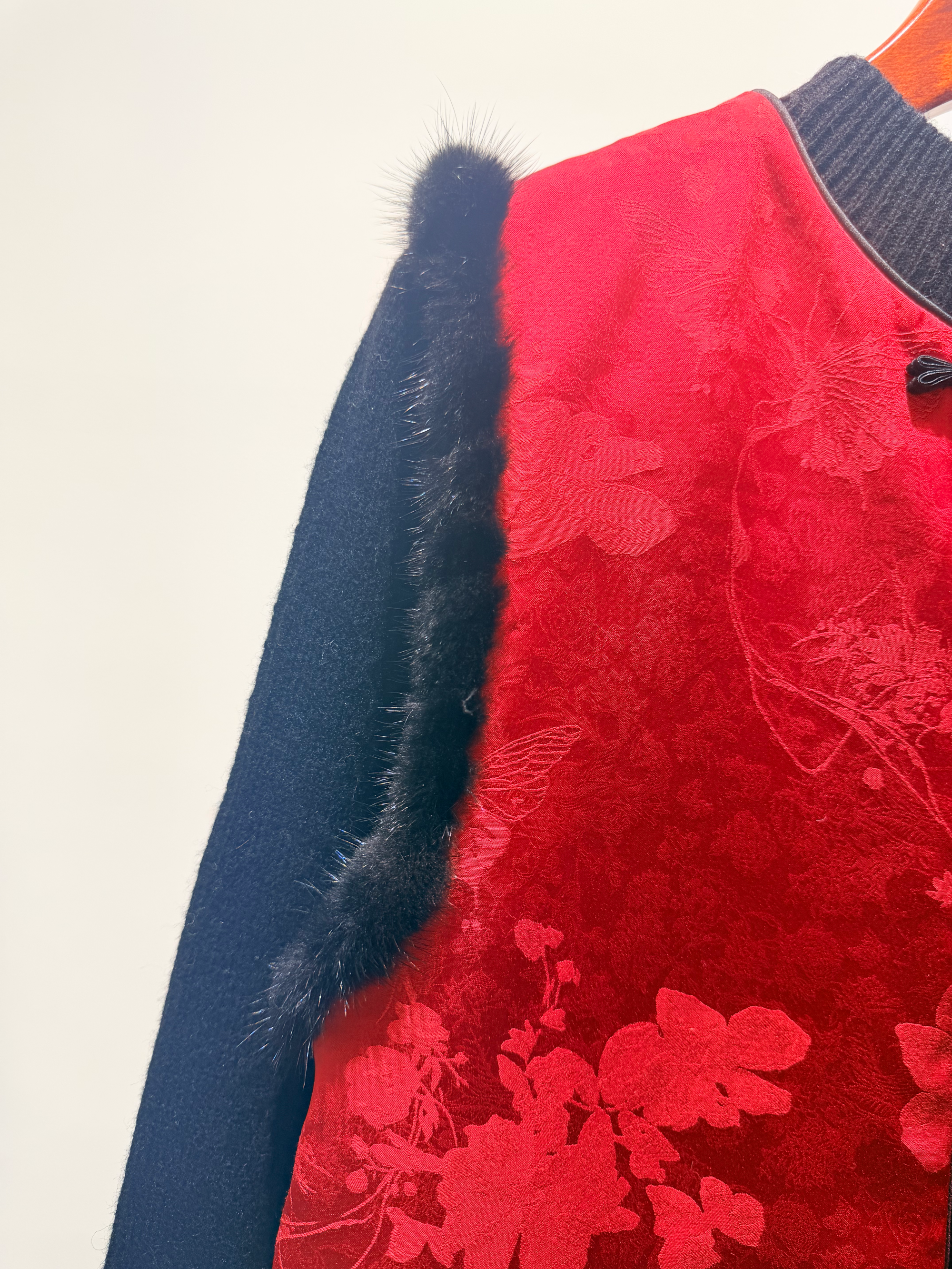 Red floral-patterned jacket with blue fur trim on a white background
