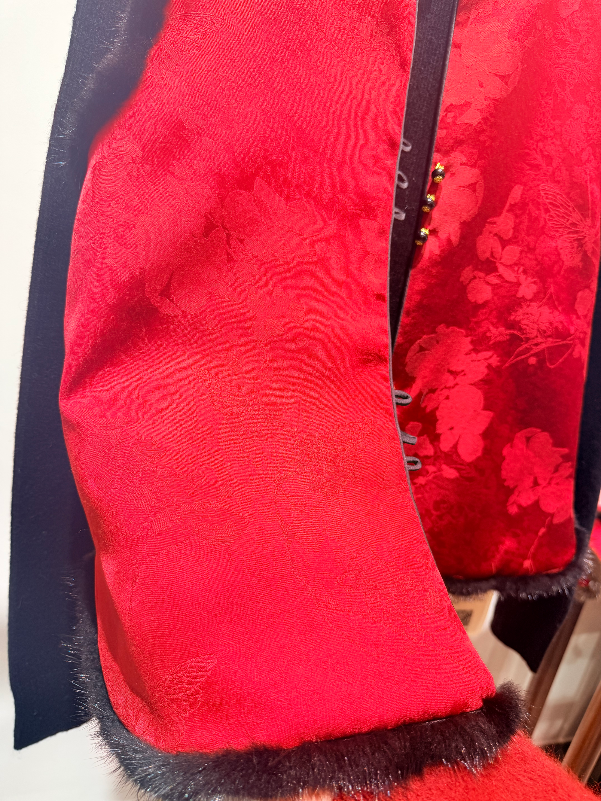 Close-up of a red textured fabric with a floral pattern on a white background