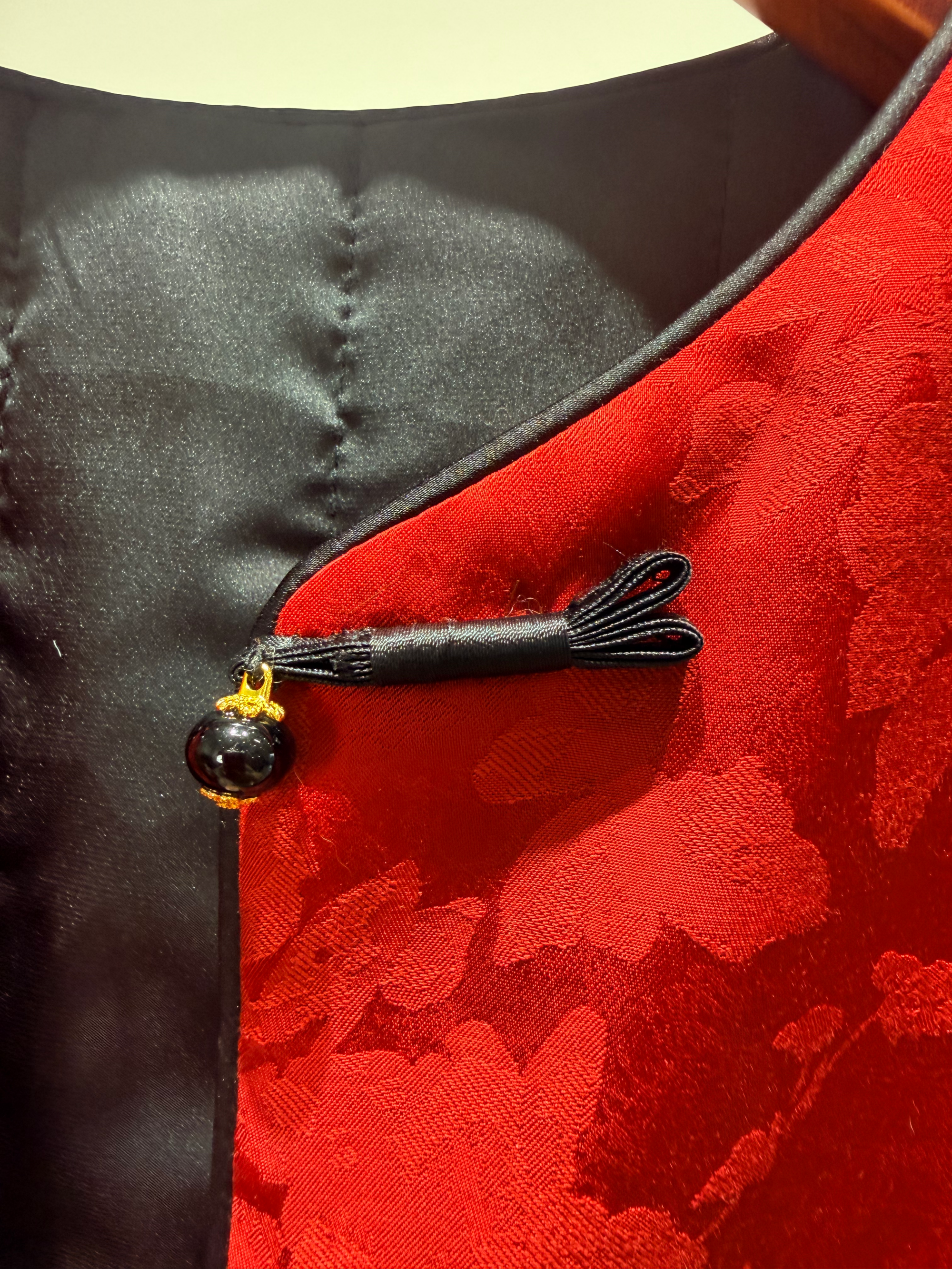 Close-up of a red garment with black decorative element