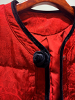 Red jacket with black lace trim and buttons on a hanger