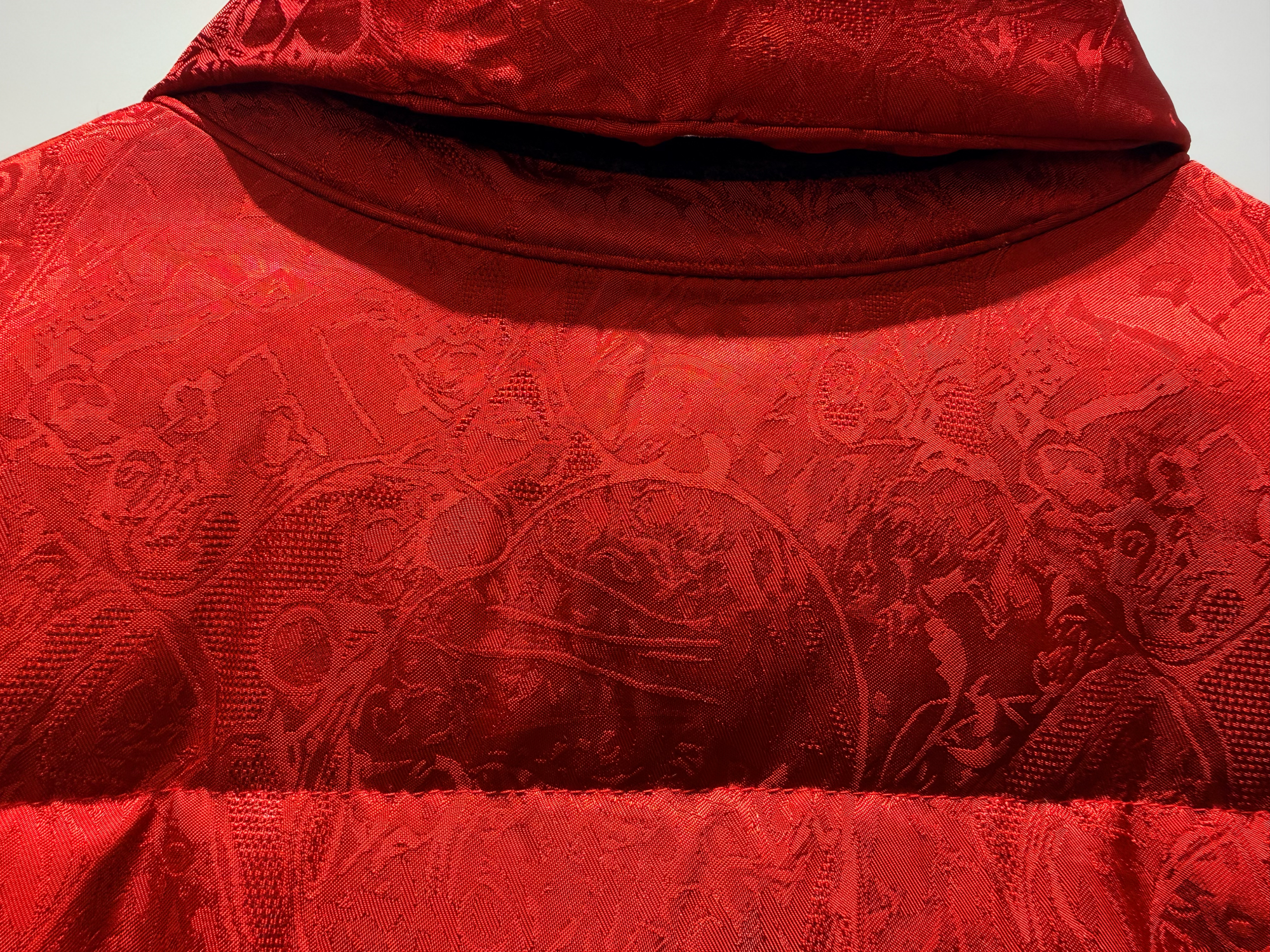 Close-up of a red textured fabric with intricate patterns