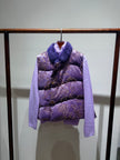 Purple puffer vest with floral pattern and fur collar on a rack