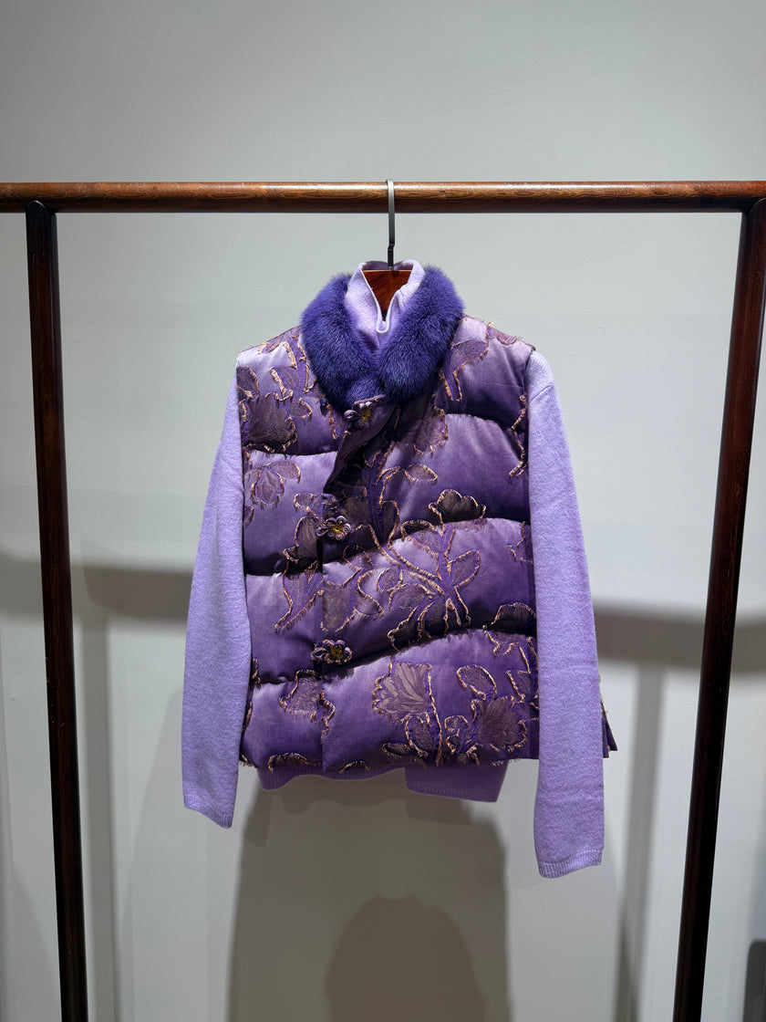 Purple puffer vest with floral pattern and fur collar on a rack