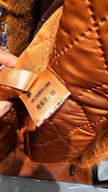 Brown leather product with a label held by a hand