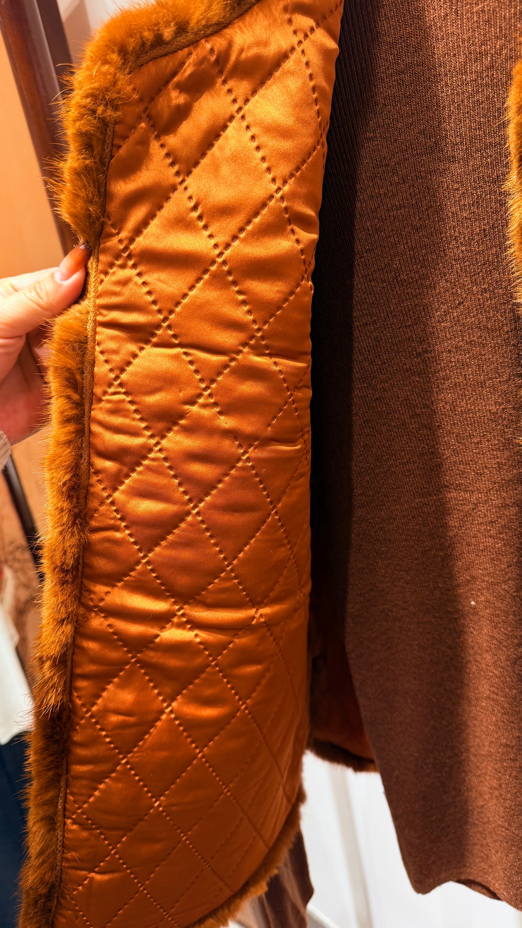 Close-up of a brown quilted jacket with fur trim