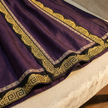 Purple fabric with gold embroidery details close-up