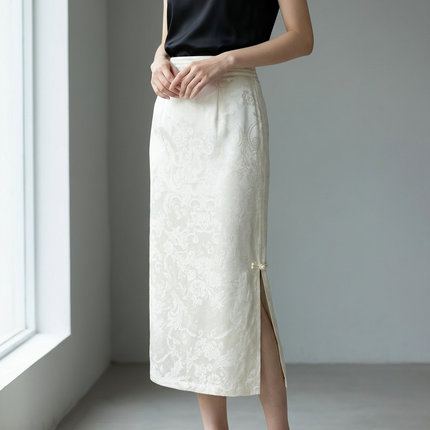 Person wearing a white rayon skirt with a black top in a minimalistic setting.