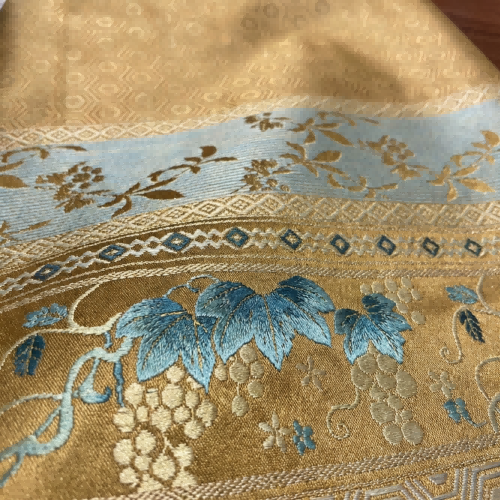 Close-up of embroidered fabric with blue floral design for the ma mian qun